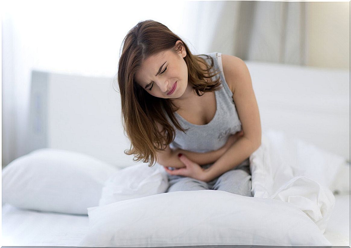 Woman with abdominal pain in bed.