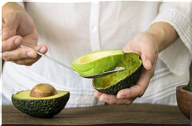 Person removing the pulp from the avocado.