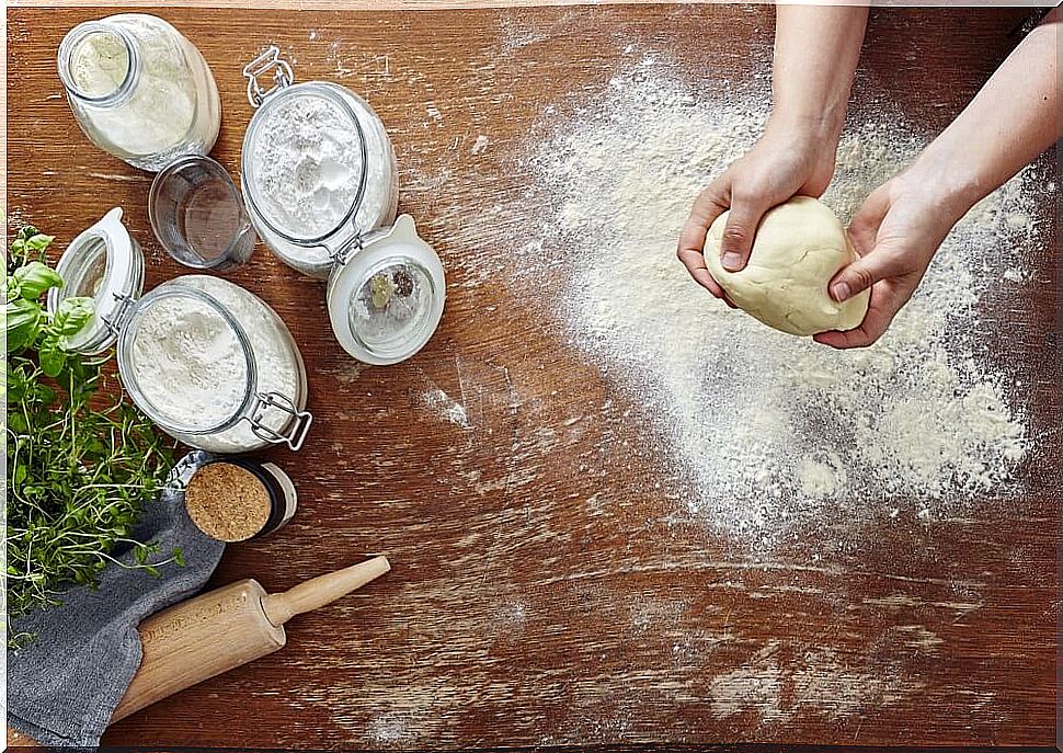 Person preparing fresh dough from flour