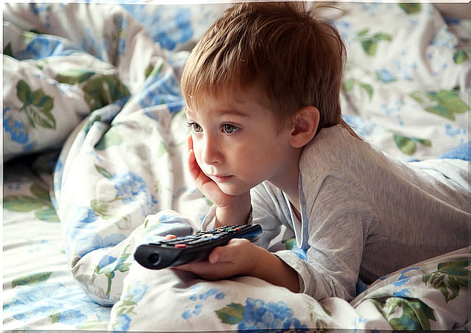 Child in bed watching television.